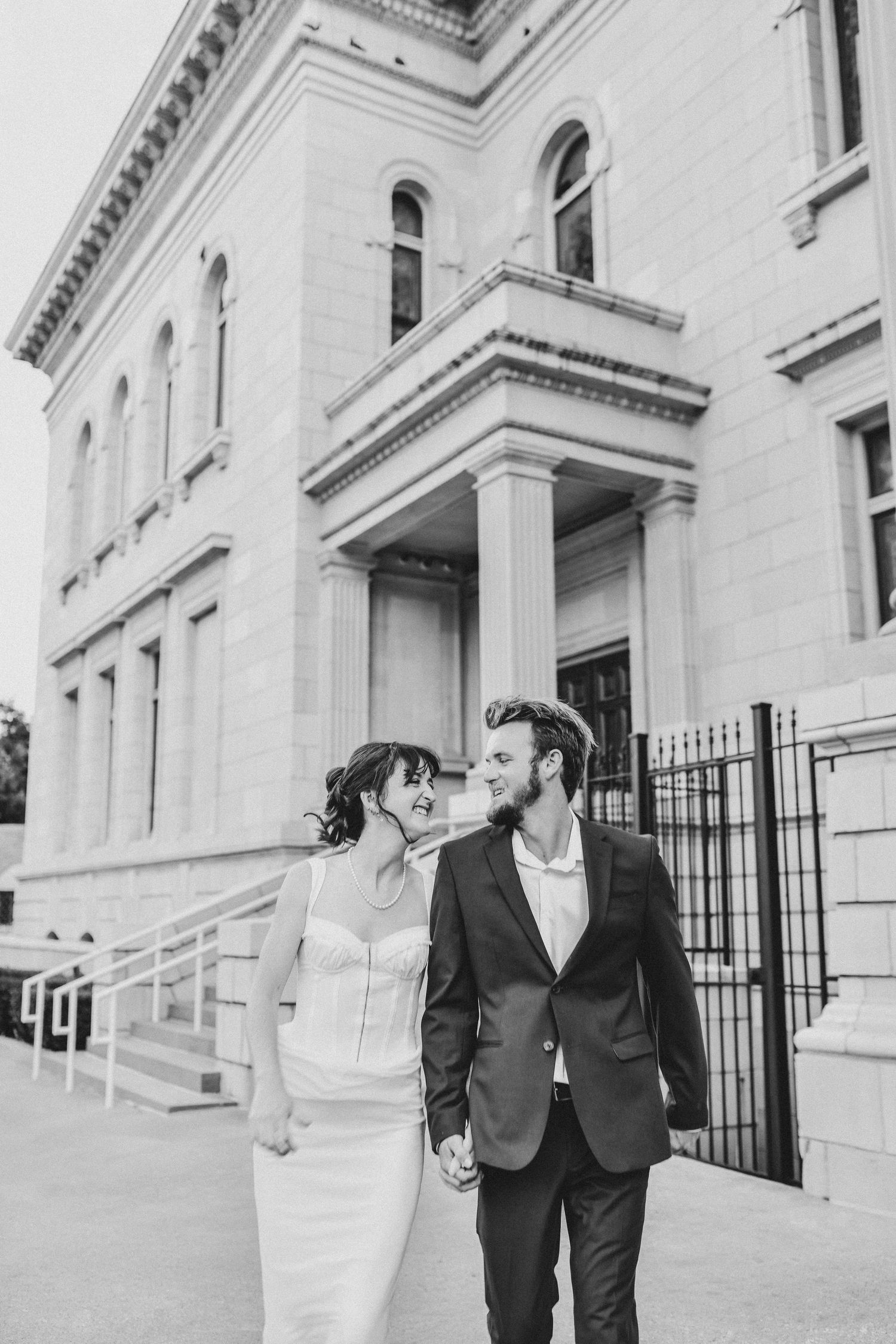Couple embracing in front of limestone cathedral walls