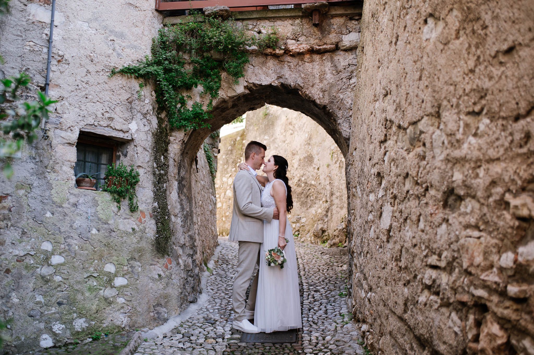 Bride and groom walk in the center of Malcesine - Lake Garda - Italy