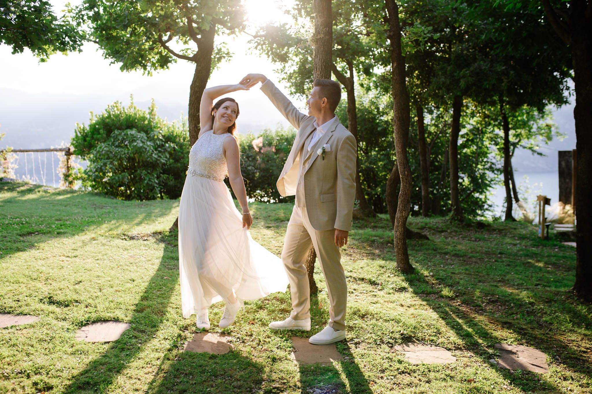 Joyful bride and groom dancing together during the sunset in Malcesine - Lake Garda