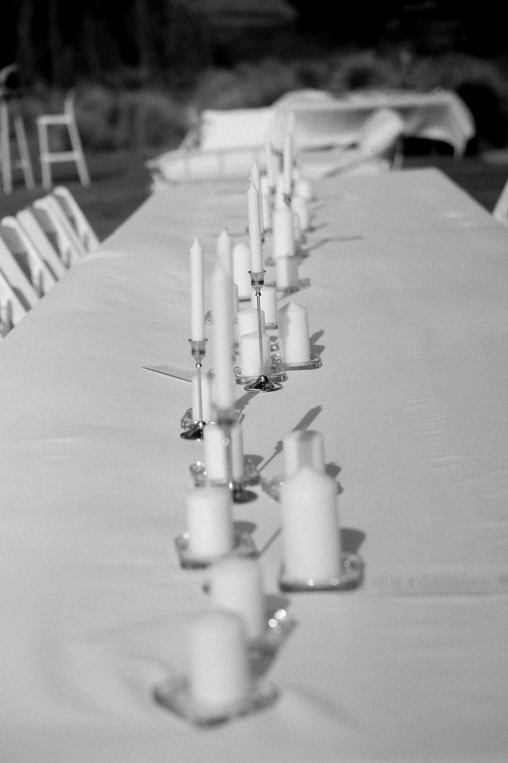 Elegant wedding reception table with candelabras and white candles in black and white photo.
