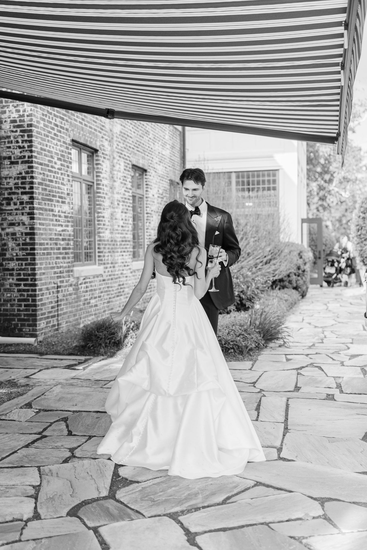 Bride and groom share a romantic moment at an elegant outdoor wedding reception with American flag backdrop.