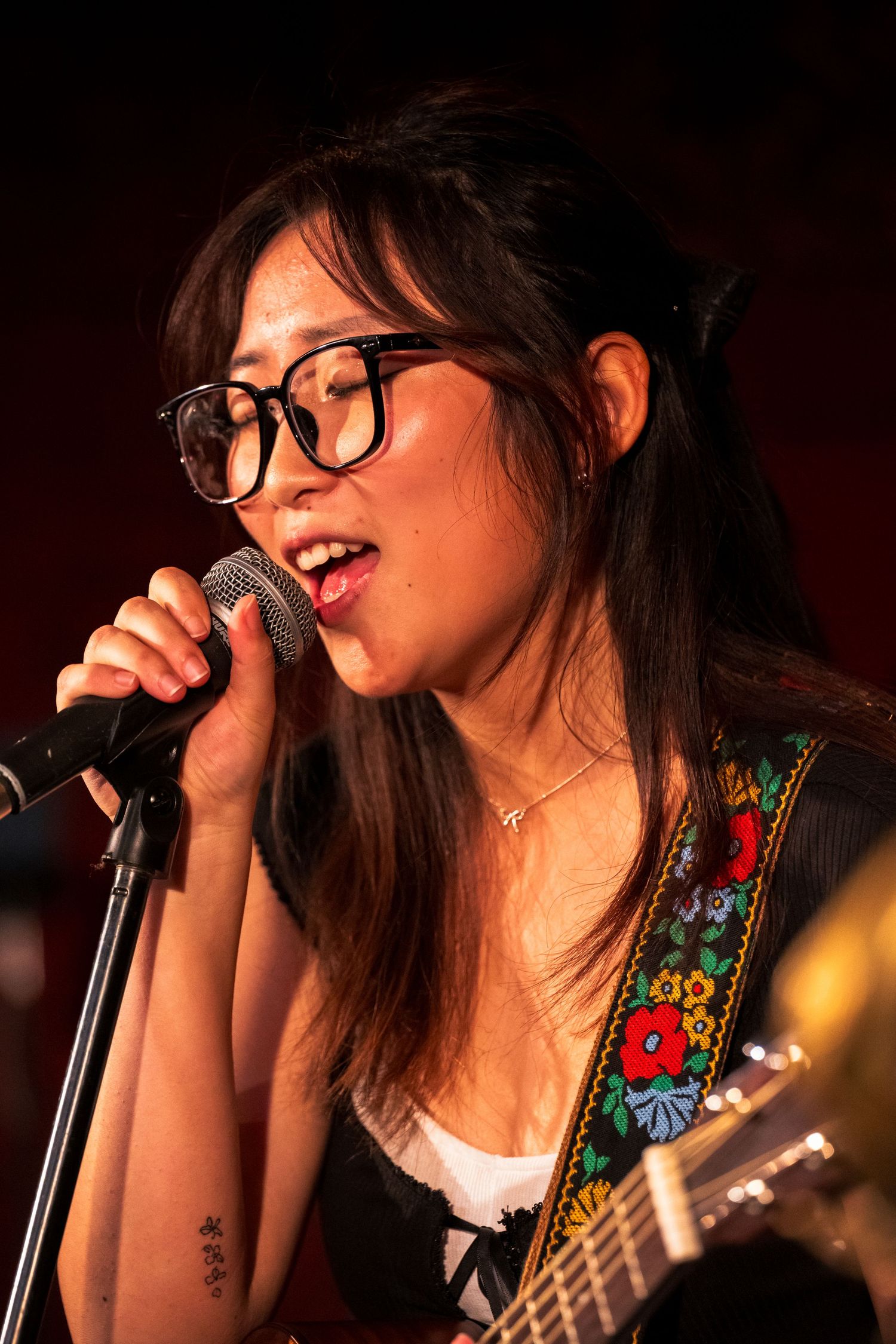 Chiani "Chiabiee" singing into a mic at Bar Lubitsch in LA. Performing for the show, "drawn to your glow".