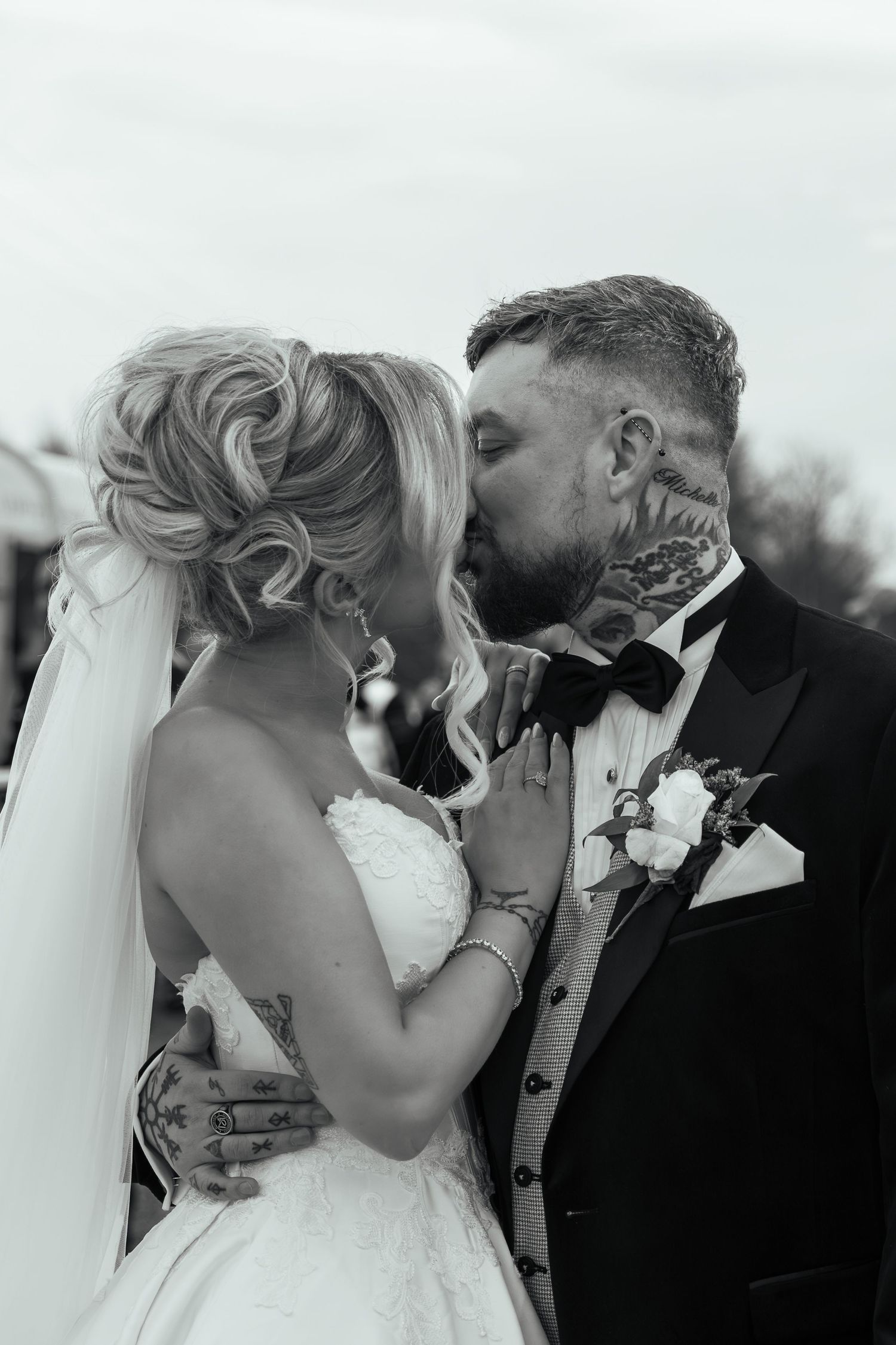 A romantic moment between newlyweds in formal wedding attire captured in a series of candid outdoor photos at dusk.