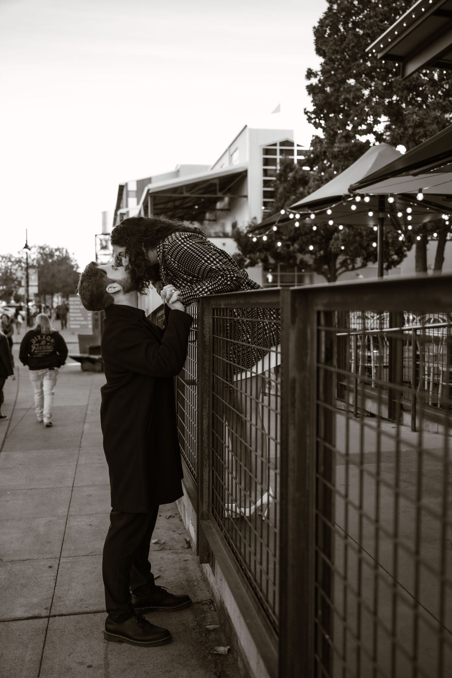 Black and white series of a proposal moment along an urban fence.