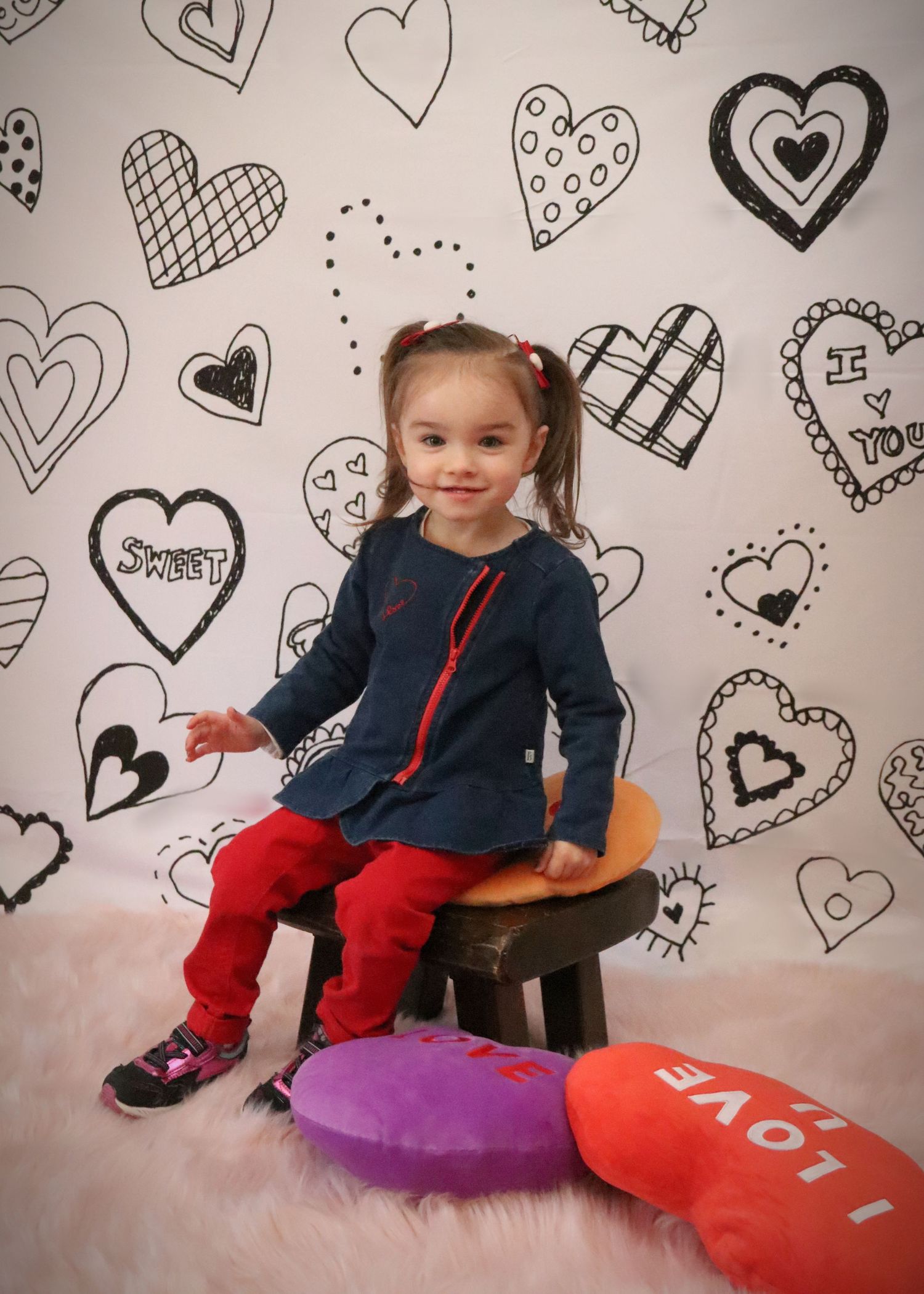 Heart-patterned backdrop with decorative drawn hearts in black and white.