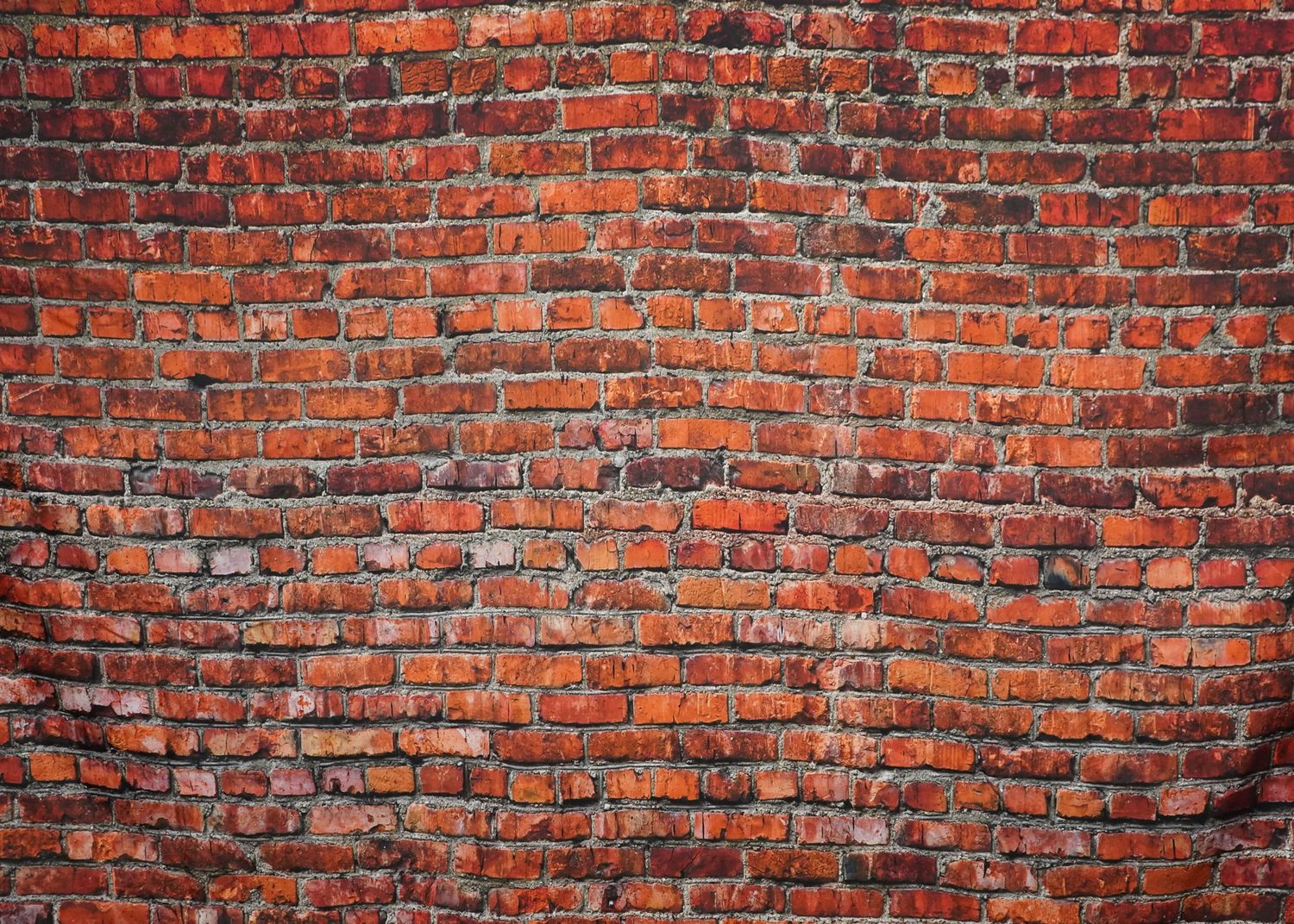 Vintage red brick wall texture with weathered mortar joints.