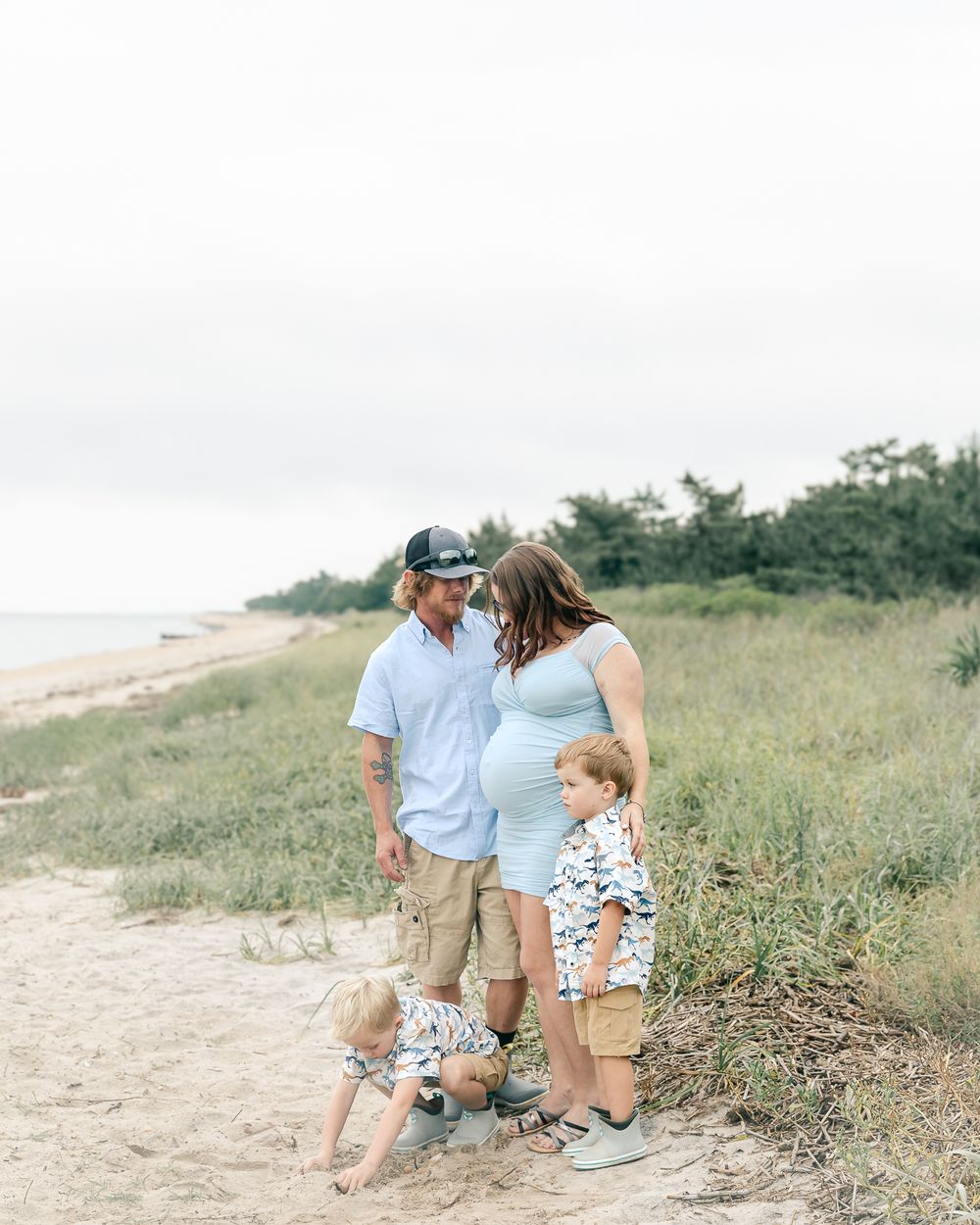 A family walks together on a coastal path during a summer day.