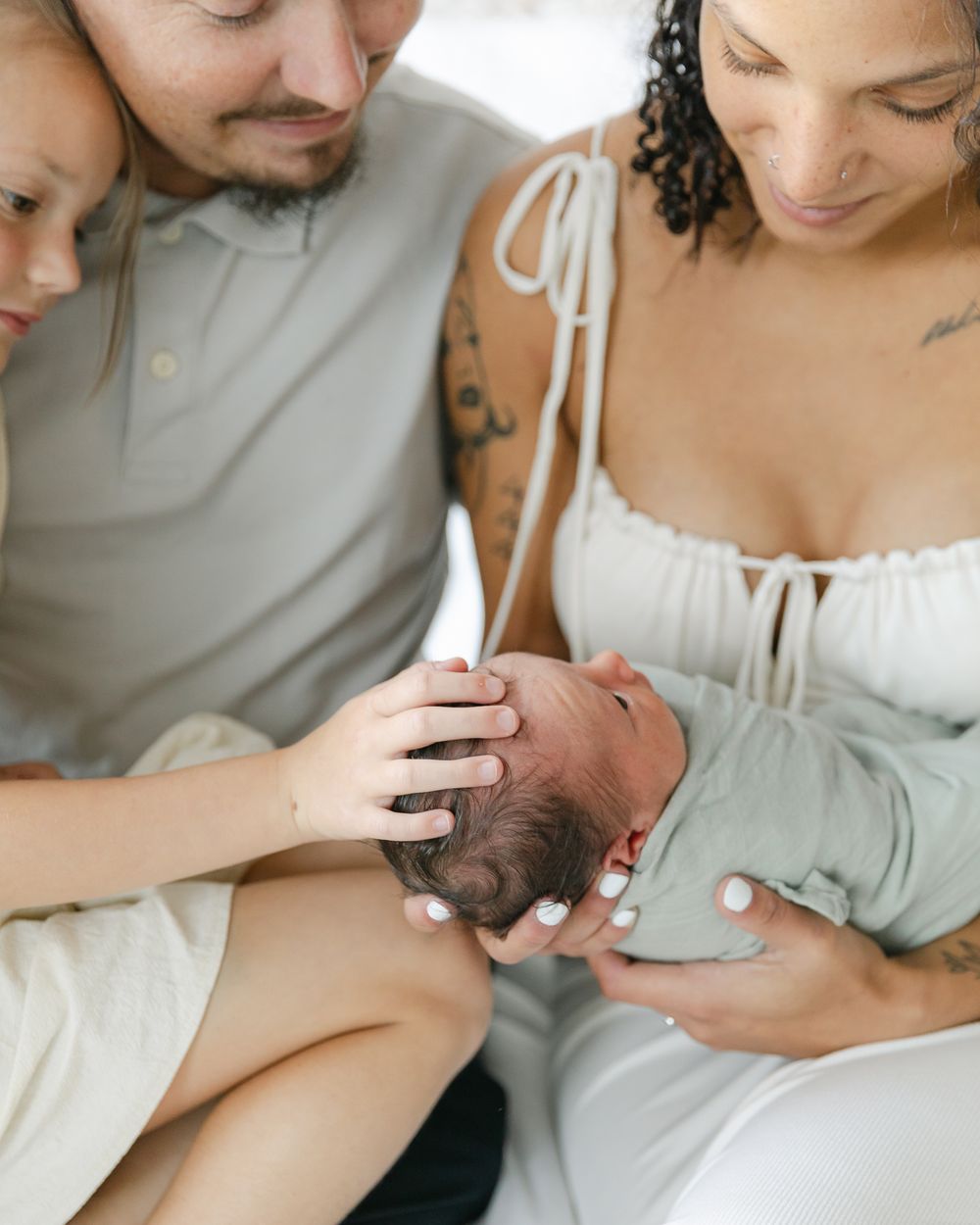 A family shares an intimate moment with their newborn baby.