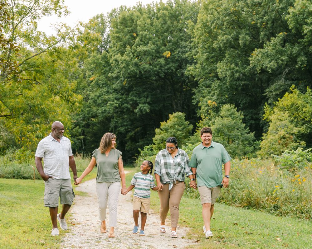 A diverse family walks together on a nature trail in summer.