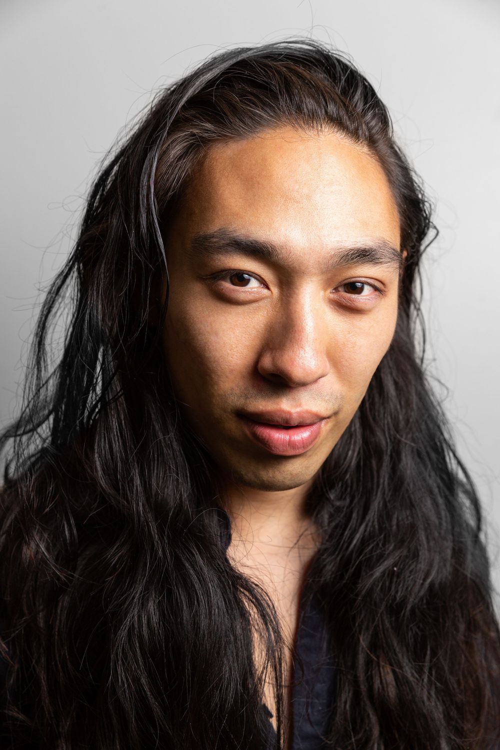A series of headshots showing different expressions and angles with long dark hair against a light background.