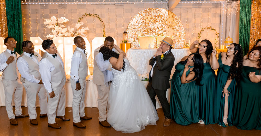 Wedding party celebrating in elegant green and white decorated venue.