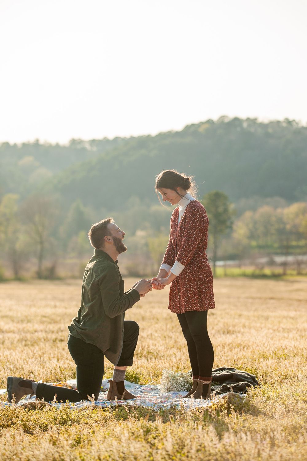©AnnaVonRiesenPhotography Engagement Portrait | Color image of a man proposing to his fiancee in a field