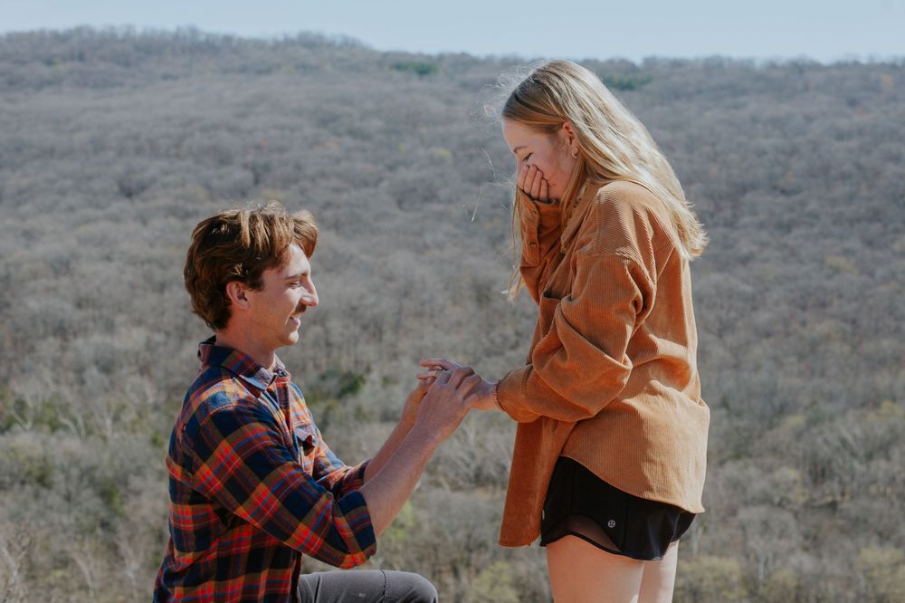 ©AnnaVonRiesenPhotography Engagement Portraits | Color image of a man proposing to his fiancee as she looks happily surprised
