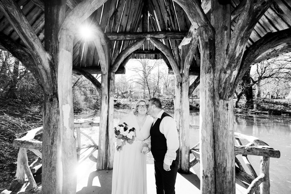 Black and white artistic wedding photo captured under a rustic wooden gazebo at Wagners Cove Central Park NYC.
