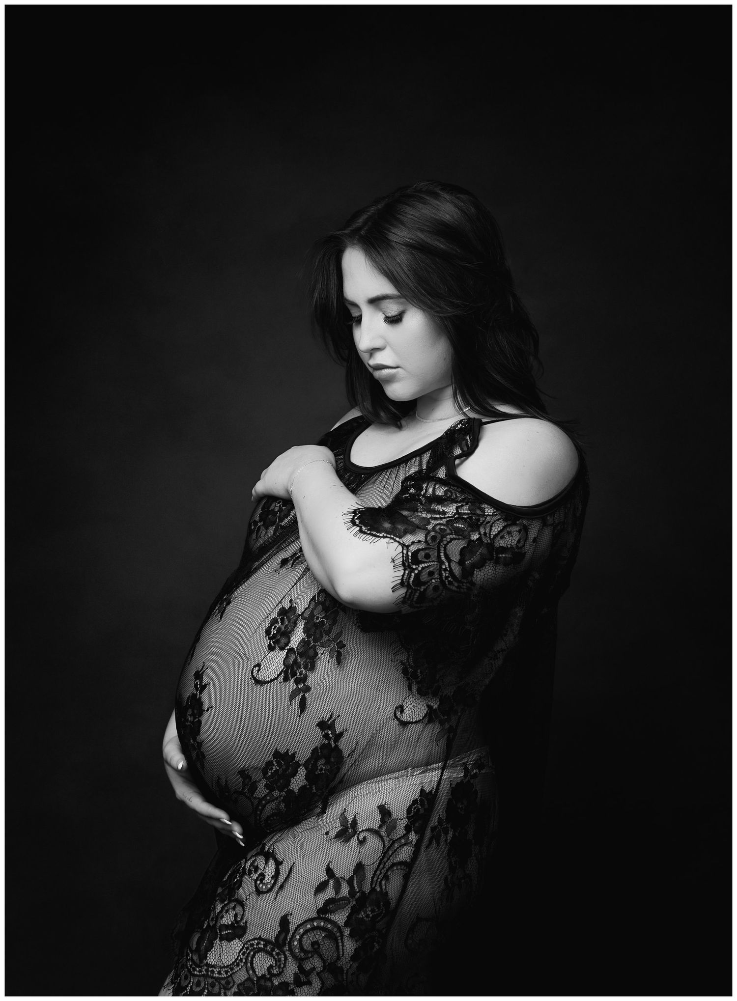 Studio maternity portrait of expectant mother in black lace open-shoulder dress take by Austin Newborn Photography