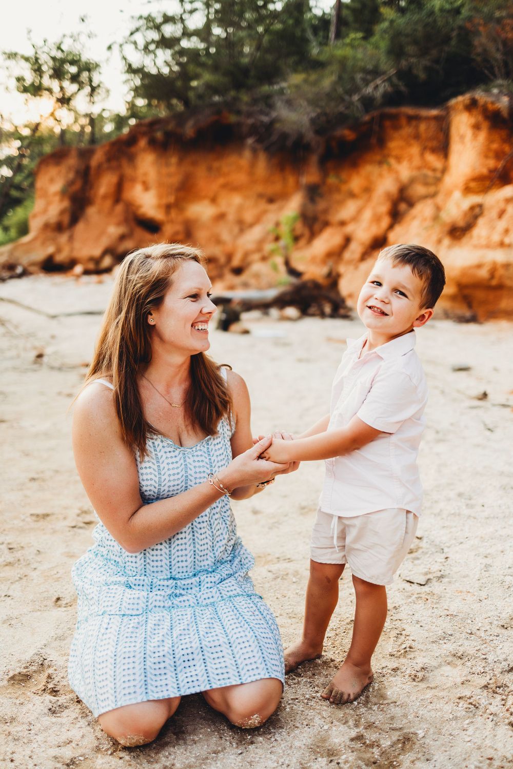 A playful interaction on a sandy beach with orange cliffs in background.