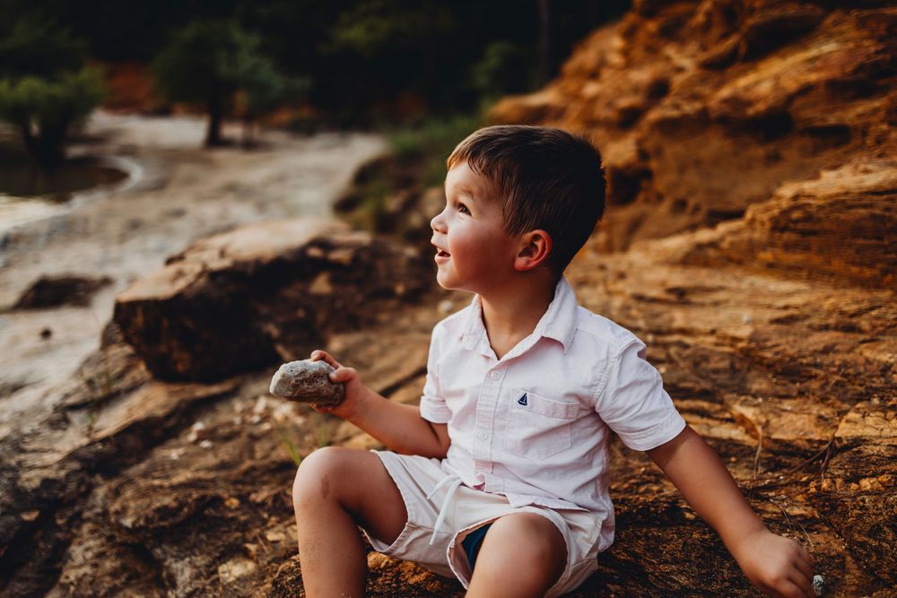 A joyful moment captured on rocky beach cliffs during golden hour.