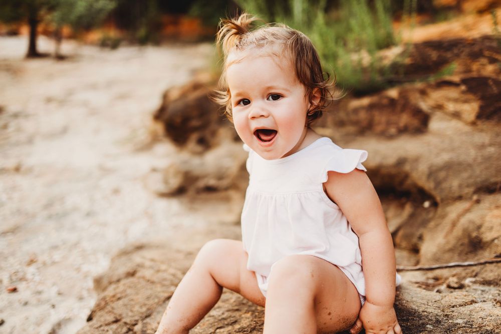 A happy expression captured against coastal rocks and sand.
