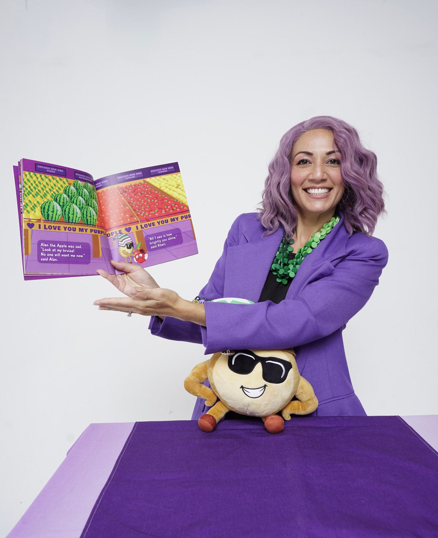 Purple-themed product photography setup with books and plush toys on display.
