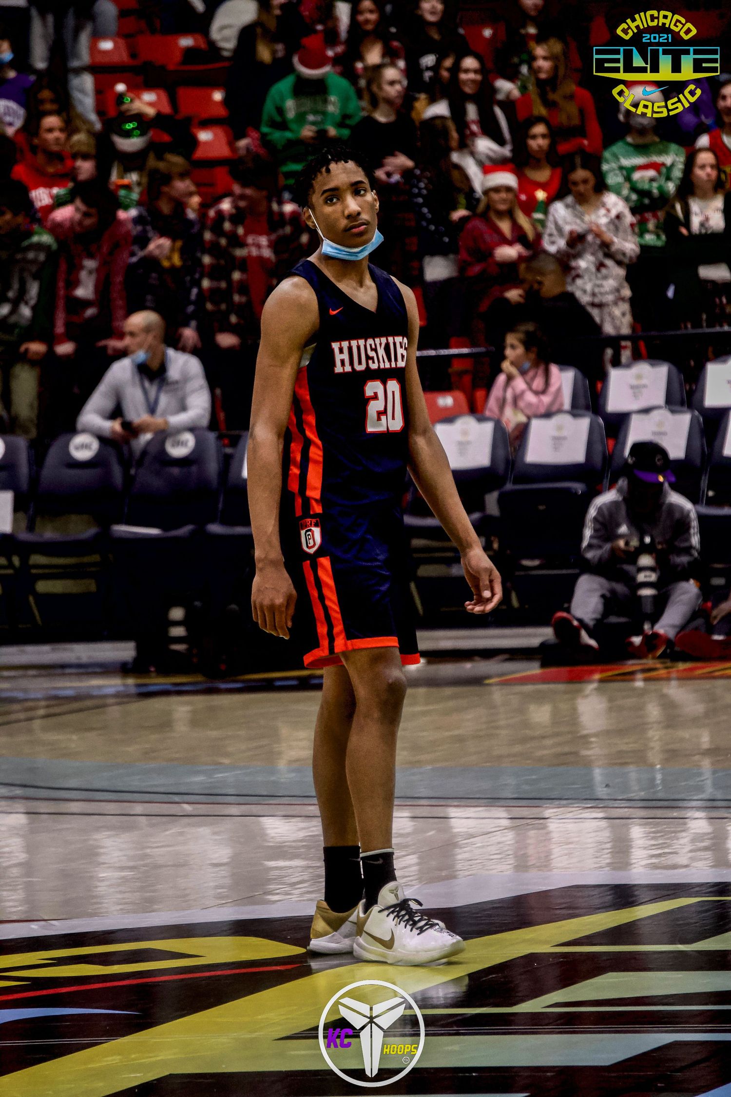Basketball player in Huskies uniform standing on court during game.