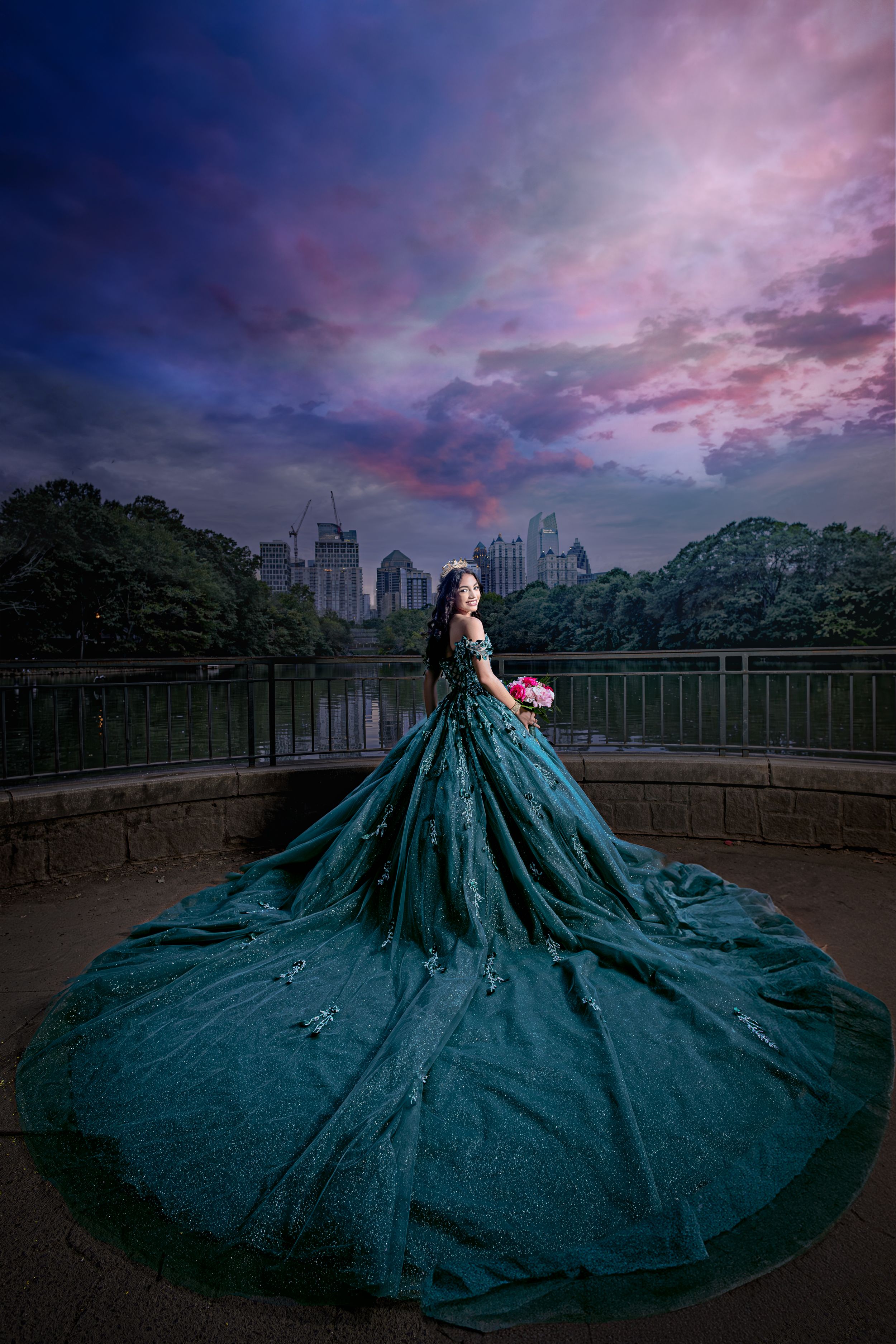 Dramatic cityscape portrait featuring an emerald ball gown against a purple sunset sky.