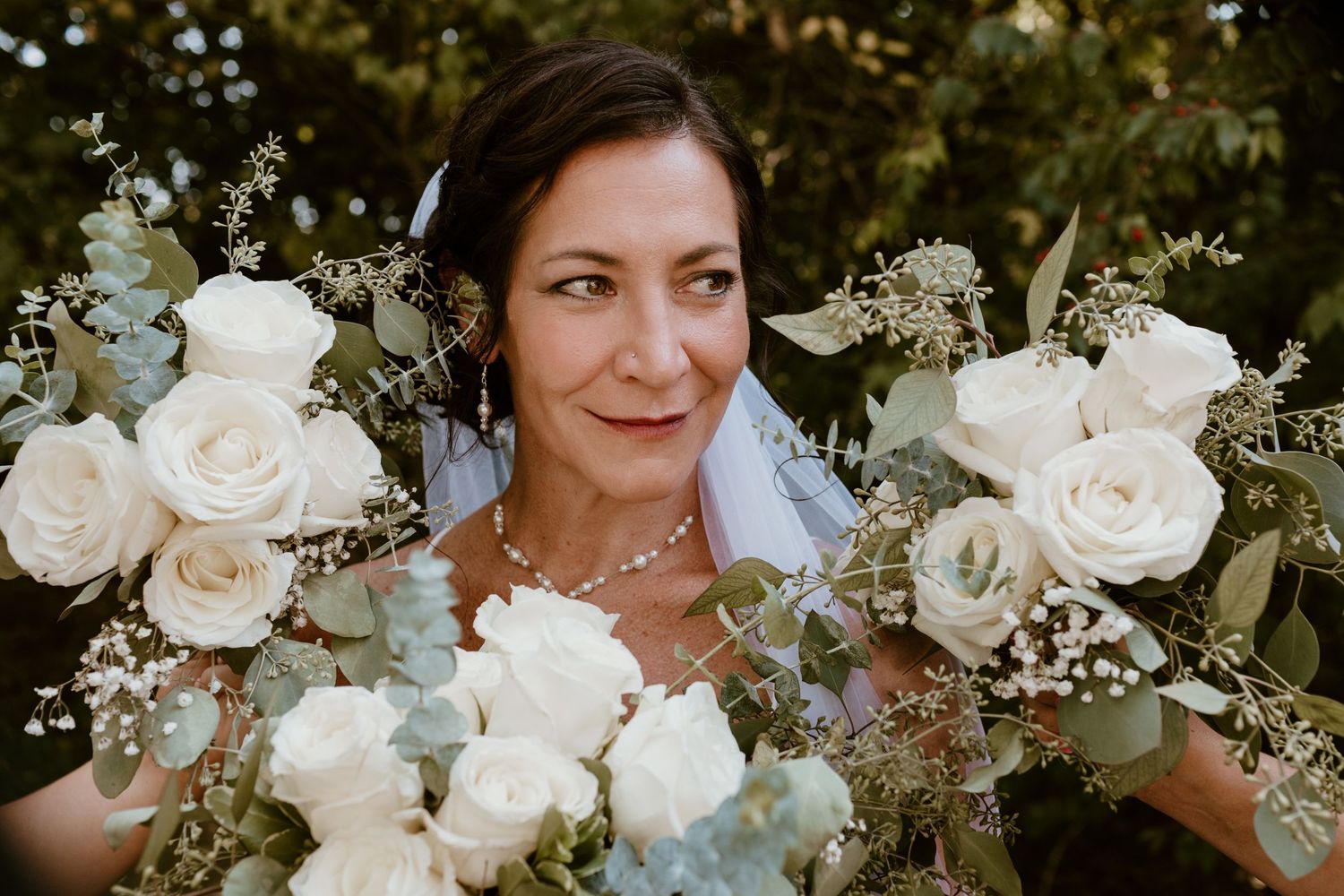 Bridal portrait with bouquets of flowers surrounding her face for summer backyard wedding in Ohio photography by Vicci Photo Dayton Ohio Pho