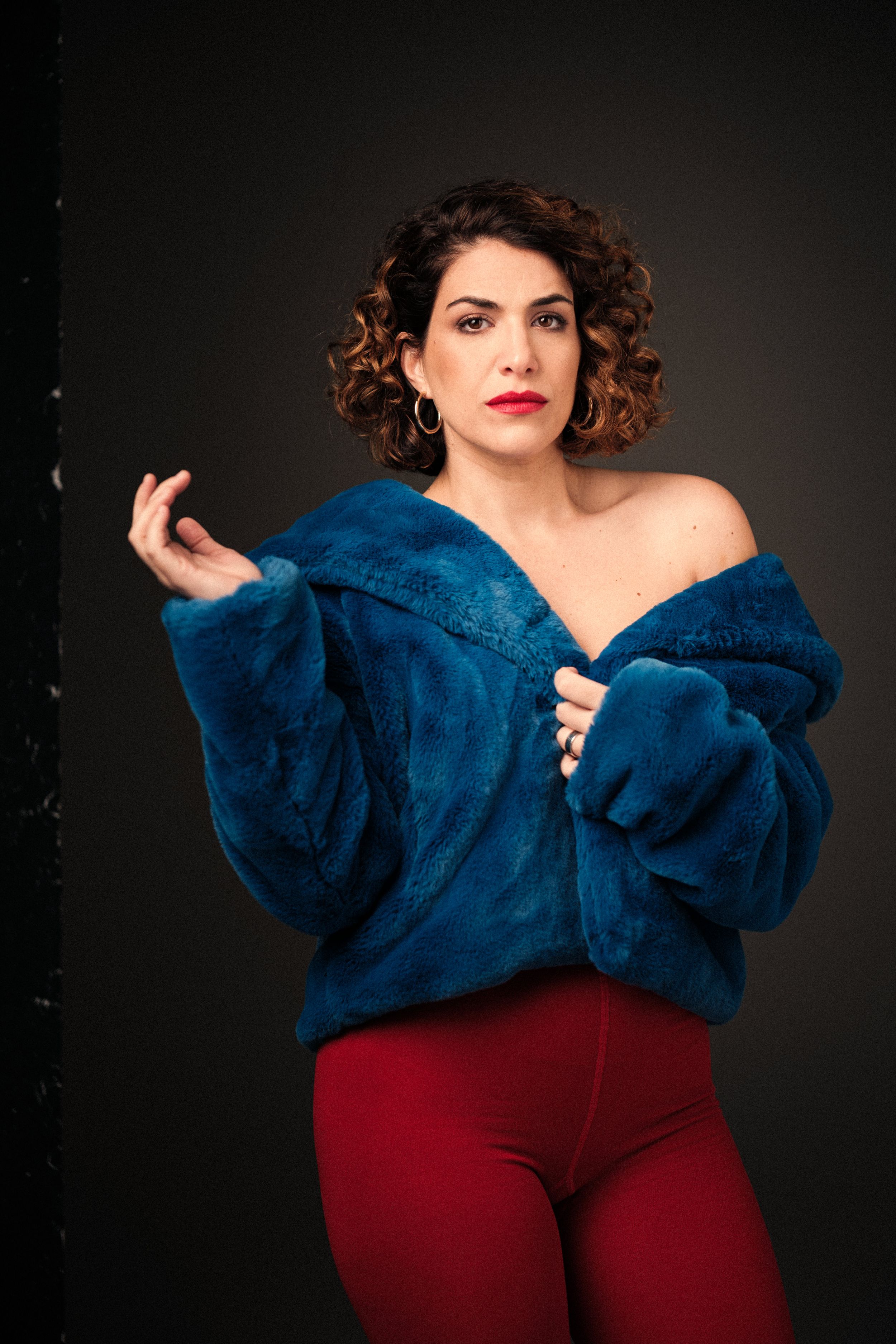 Dynamic fashion poses in bright blue coat and red pants with studio lighting.