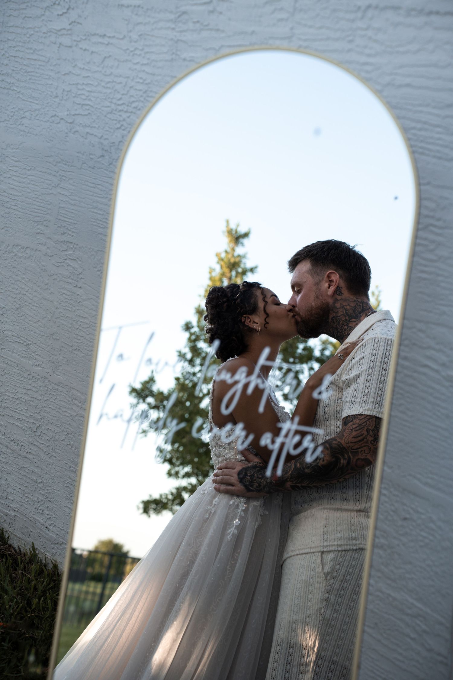 A romantic photo sequence through an arched doorway shows a couple embracing in soft natural light.