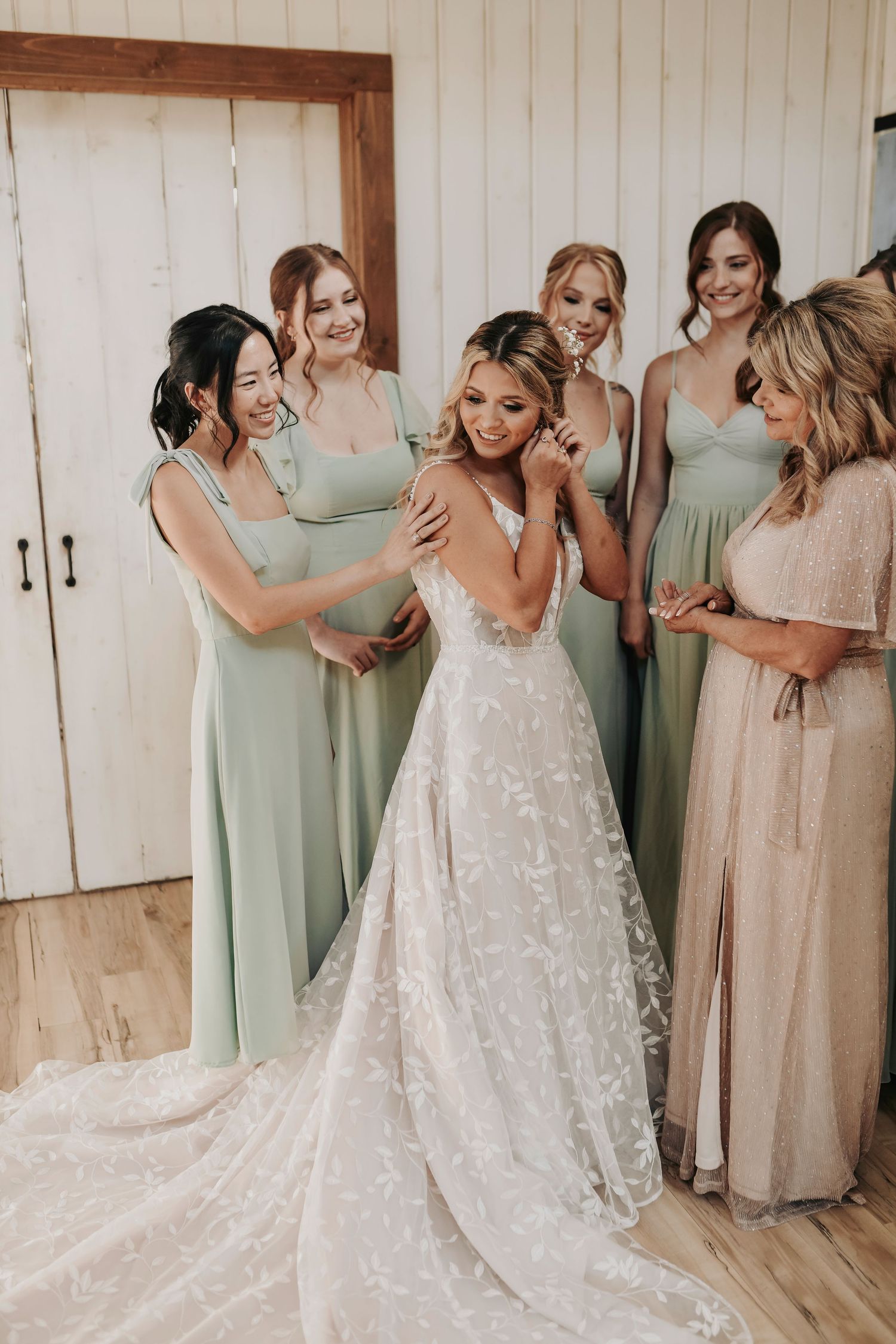 Bride’s mother helping fasten dress in bridal suite