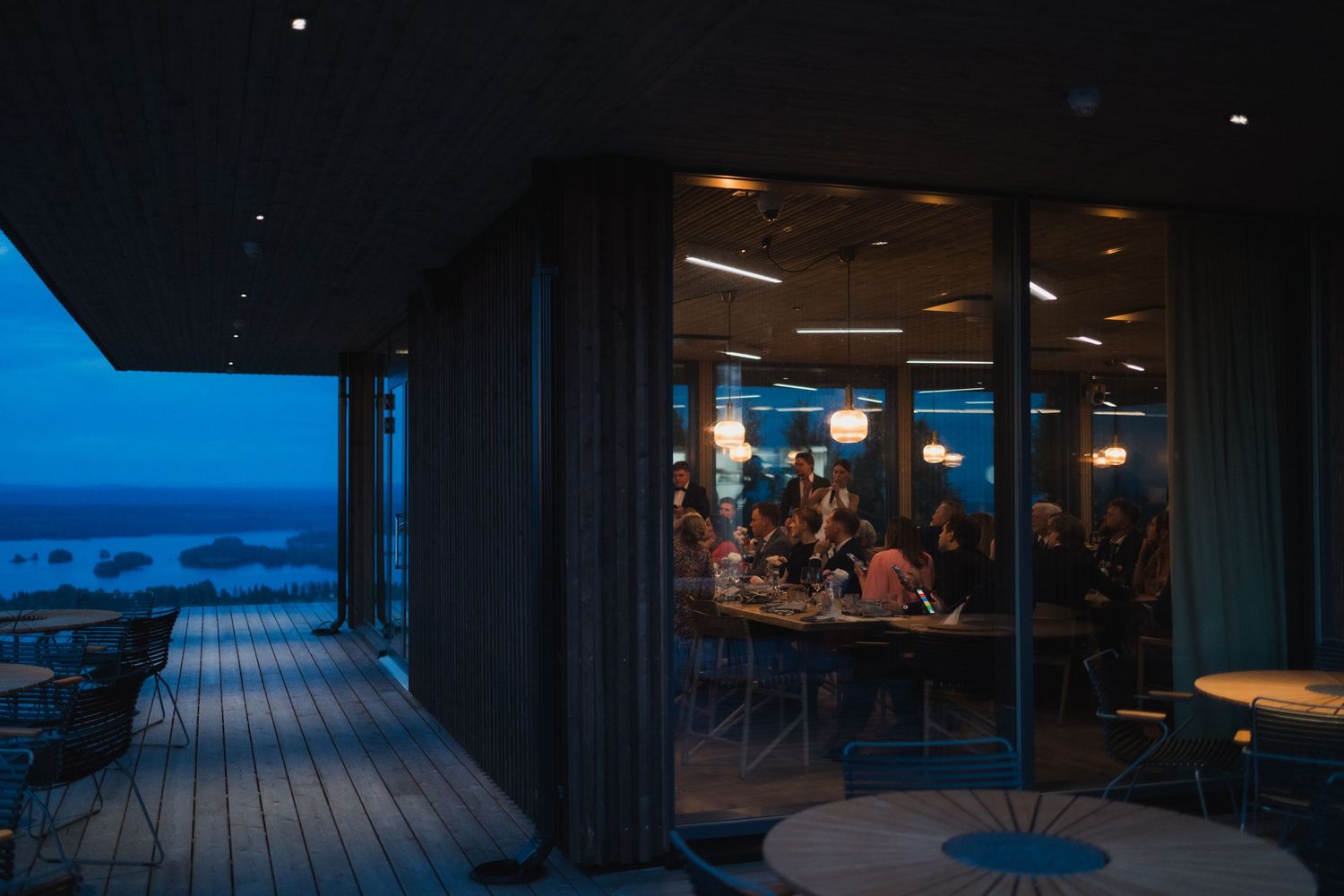 Modern outdoor deck venue at night with blue lighting and ocean views.