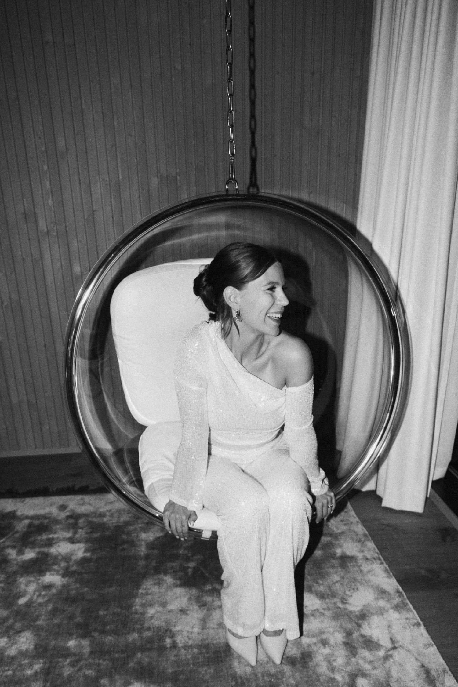 A hanging egg chair photographed in black and white with artistic motion blur.
