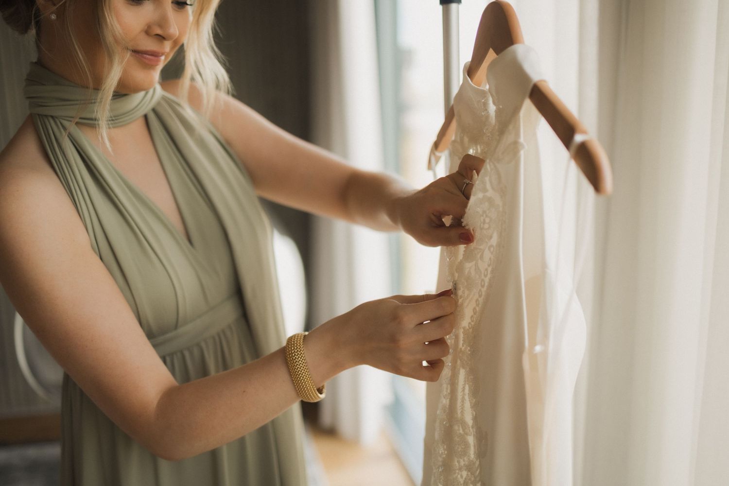Elegant dress preparations by window with natural lighting.