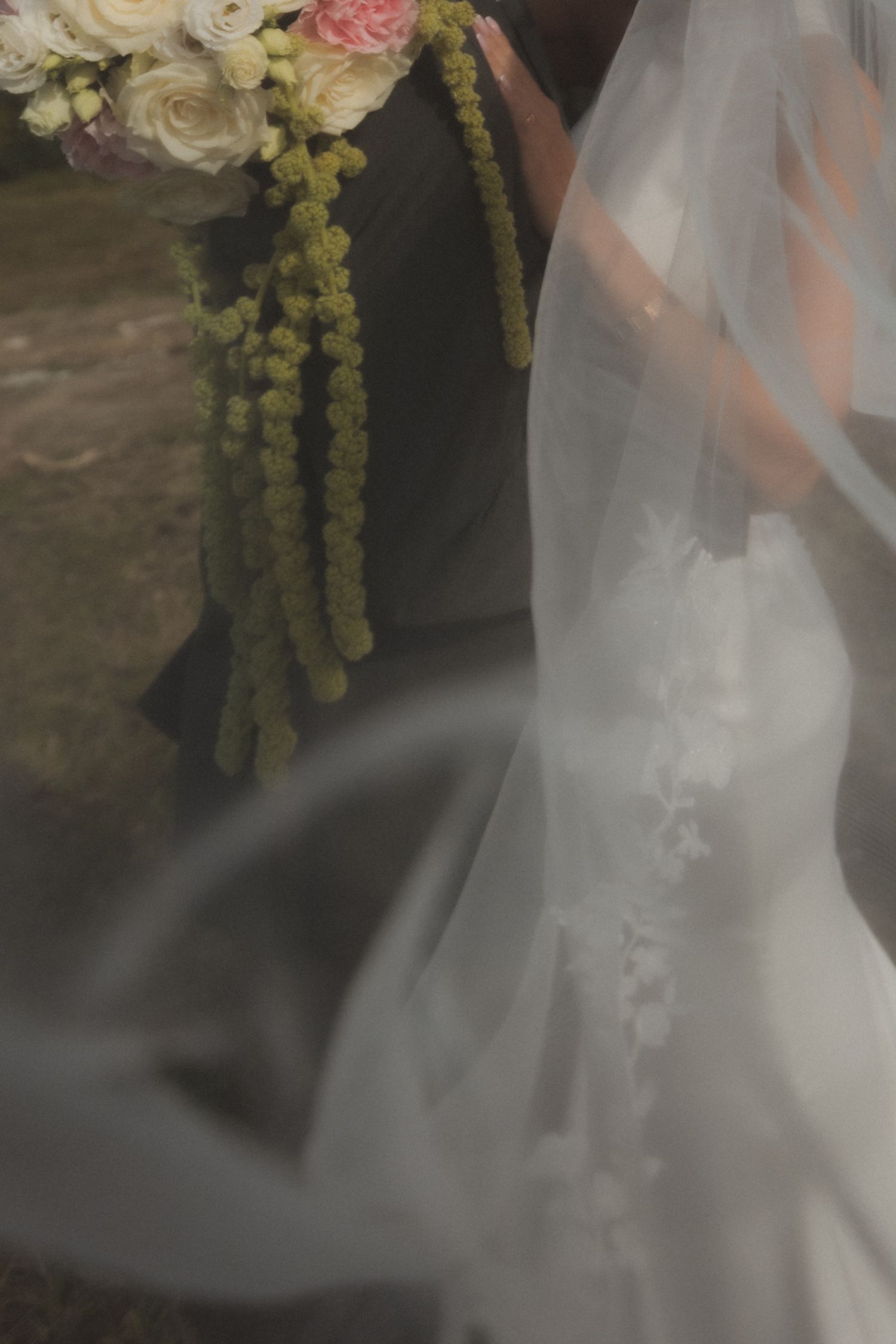 Delicate floral arrangements and white tulle veil details at a wedding ceremony.