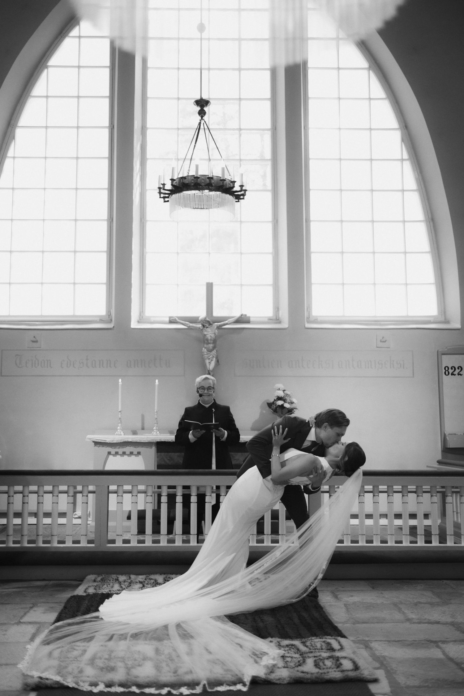 Dramatic black and white photos of a flowing wedding dress in motion inside a church.