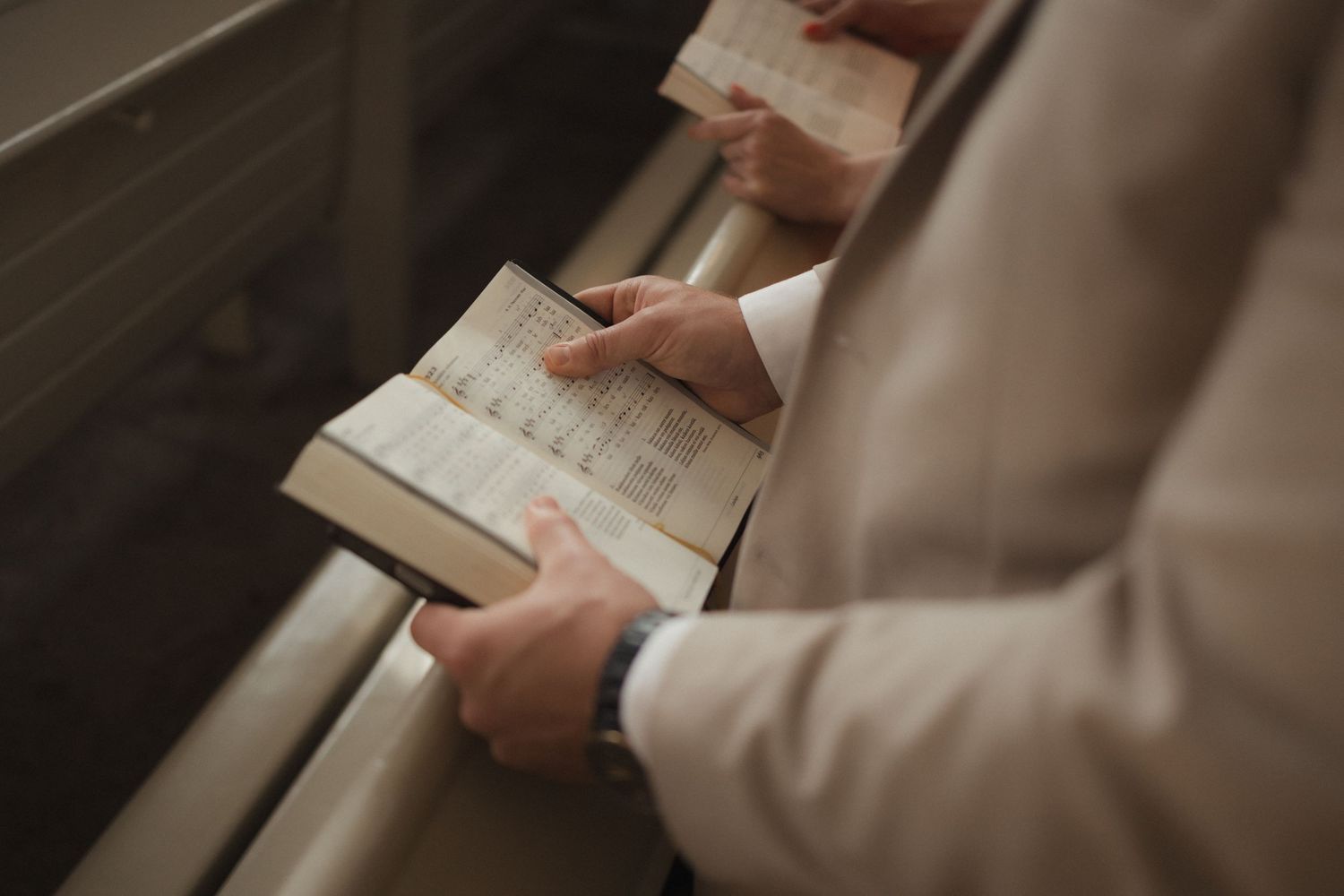 Close-up shot of hands holding a wedding ceremony program or order of service.