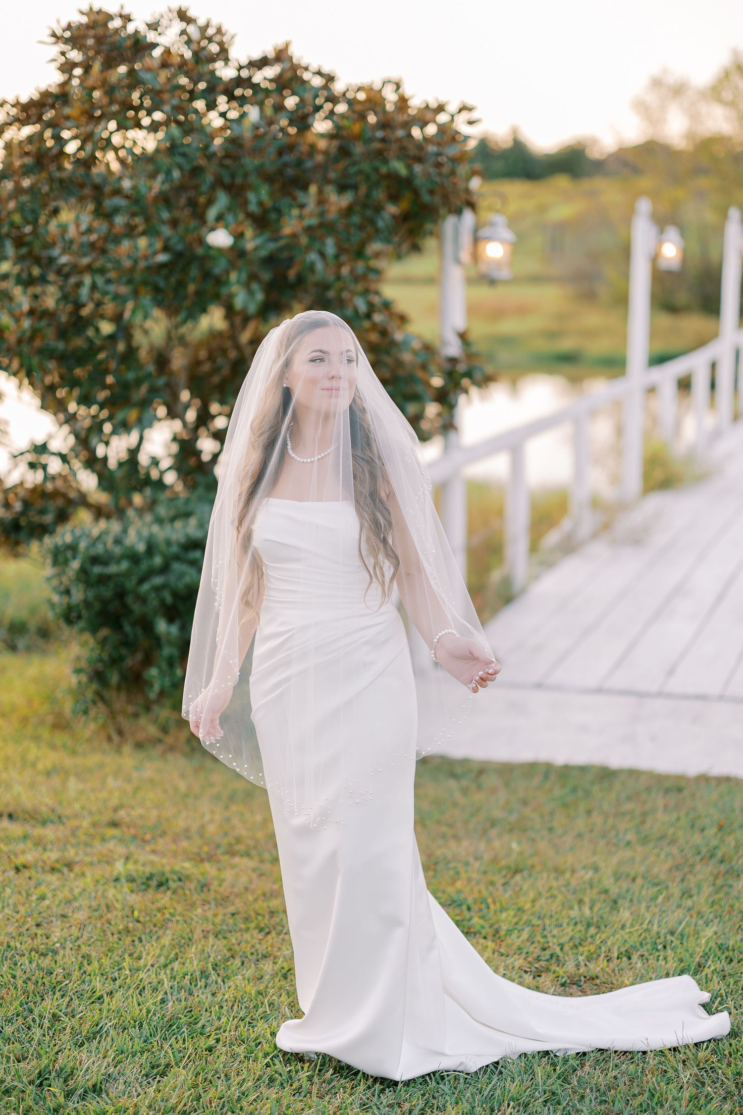 Ethereal bridal portraits showing flowing white wedding dress and veil against a natural outdoor backdrop.
