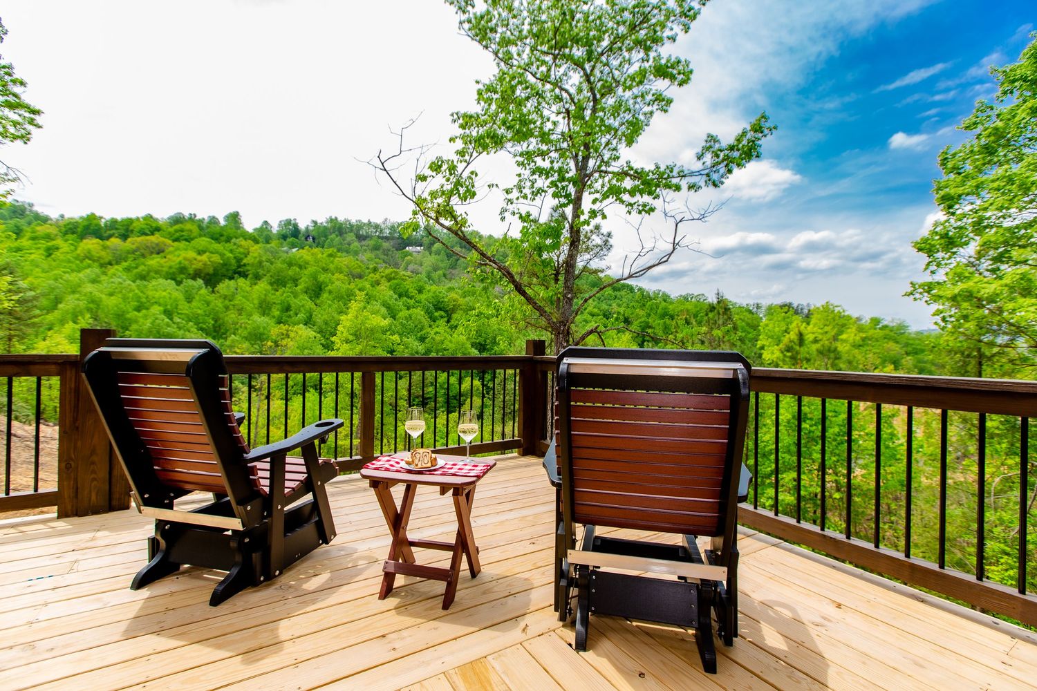 Panoramic view of a rustic cabin deck with comfortable seating and mountain vistas.