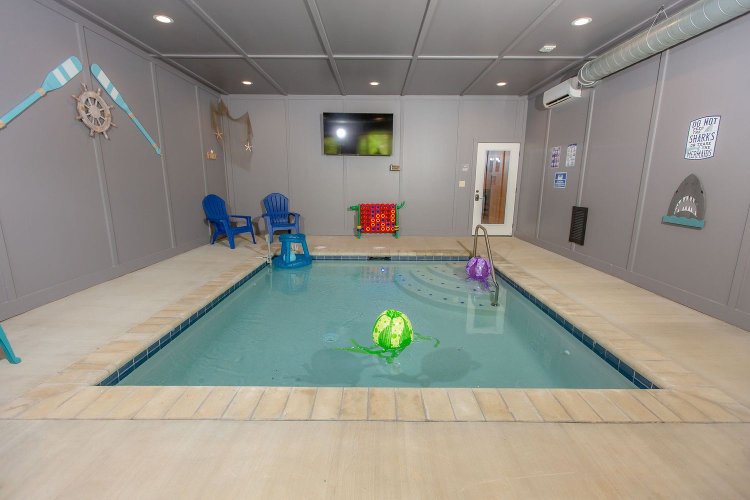Indoor swimming pool with modern amenities and blue accents in a clean, well-lit space.