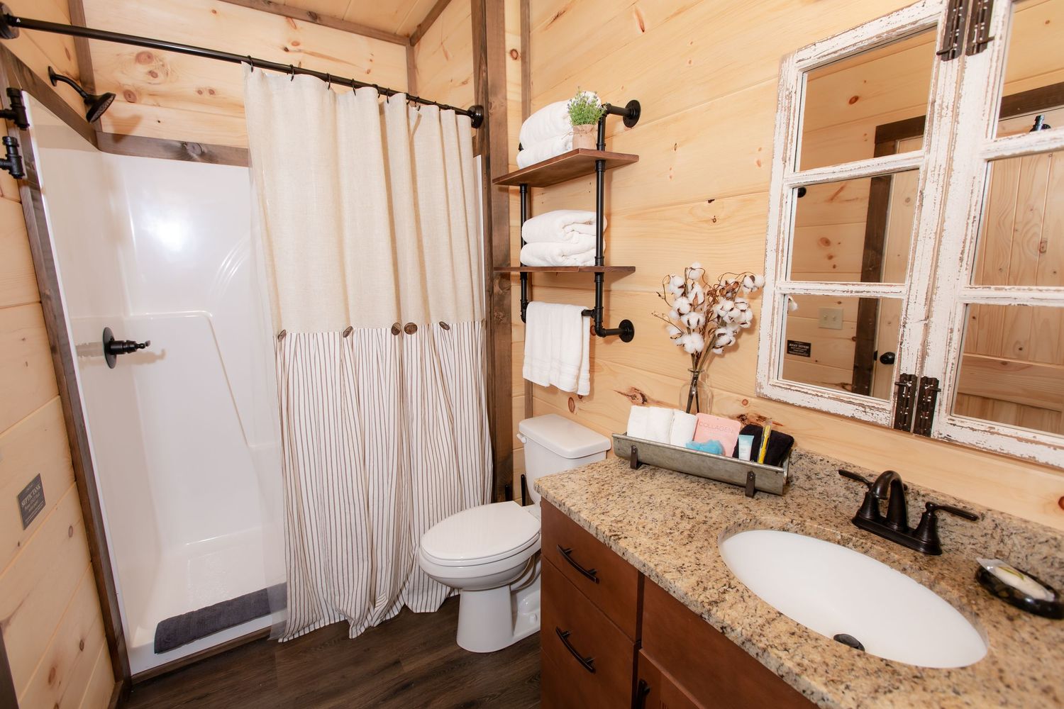 Wood-paneled bathroom interior with granite countertops and modern fixtures.