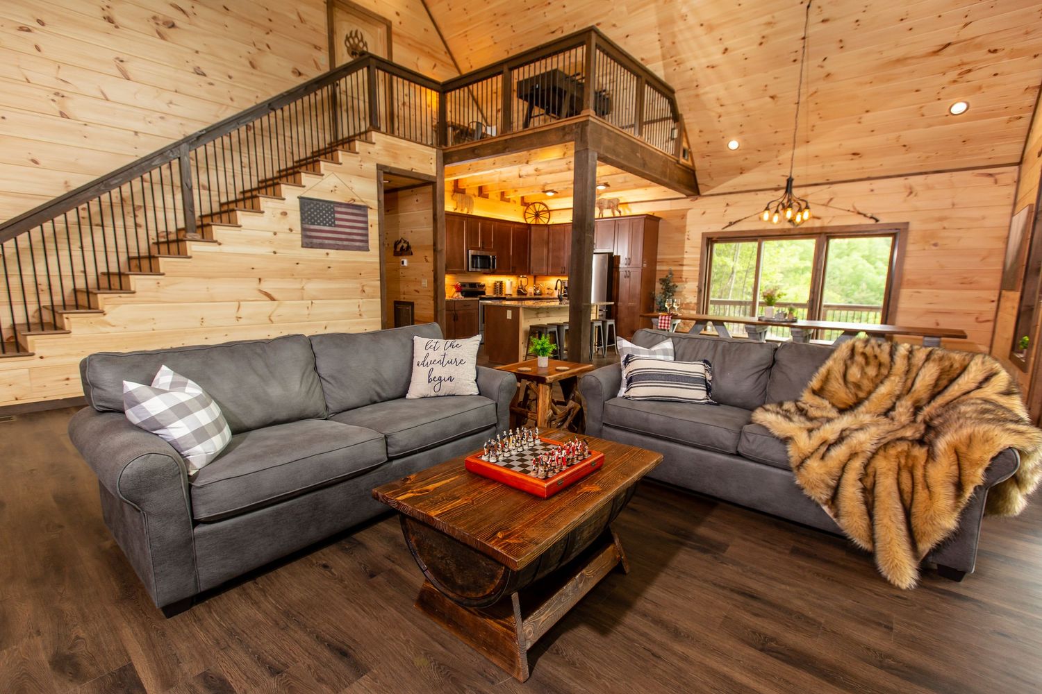 Spacious log cabin interior featuring rustic decor, grey sofas, and natural wood finishes.