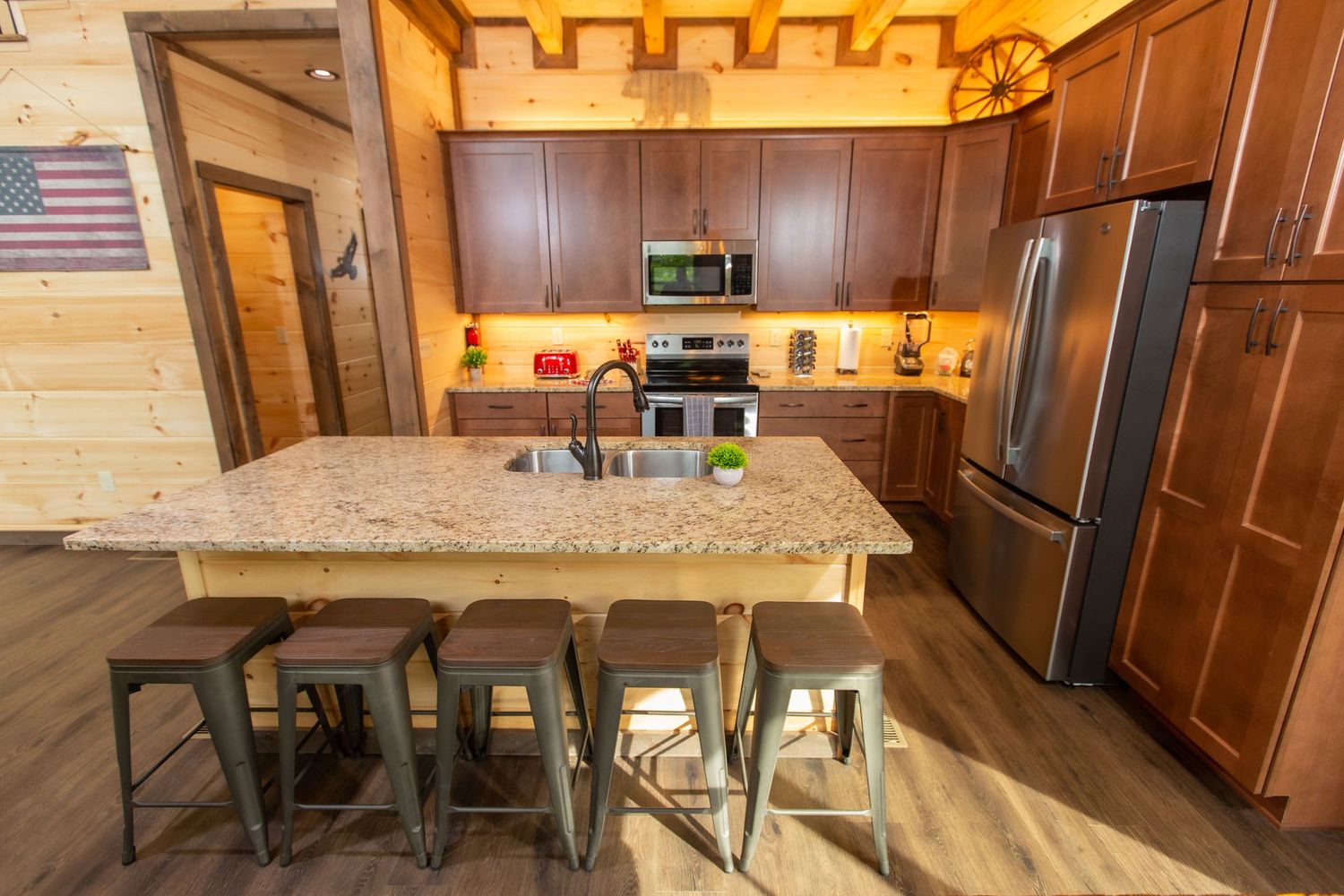 Open concept dining area with wooden tables, American flag, and rustic cabin interior design.