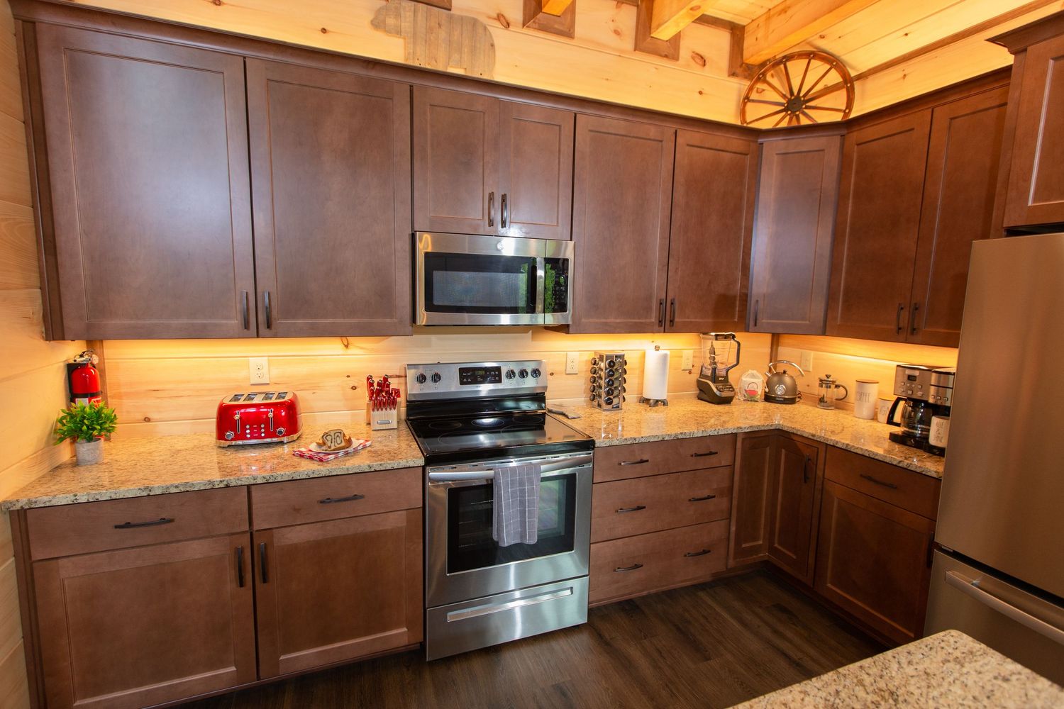 Modern kitchen with dark wood cabinets, stainless appliances, and granite countertops.