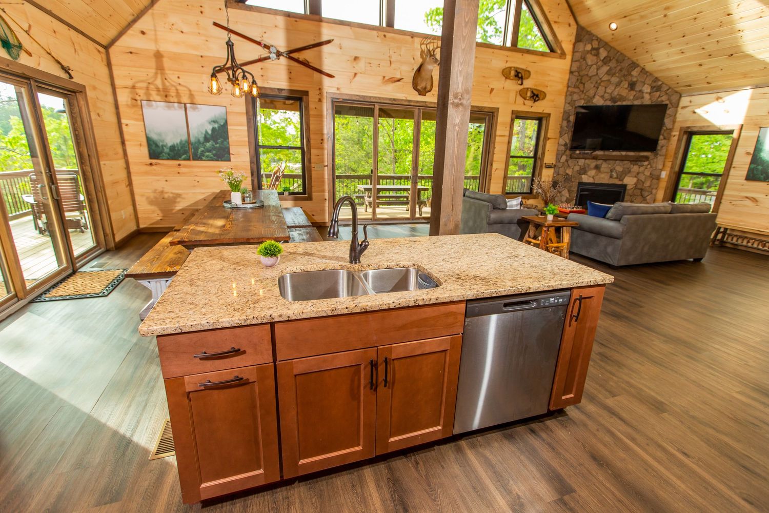 Spacious kitchen with wood cabinets, stainless appliances and large windows overlooking forest views.
