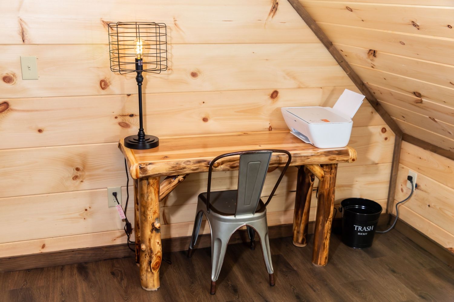 A rustic wooden wall with knotty pine paneling and mounted light fixtures creates a cozy cabin interior.