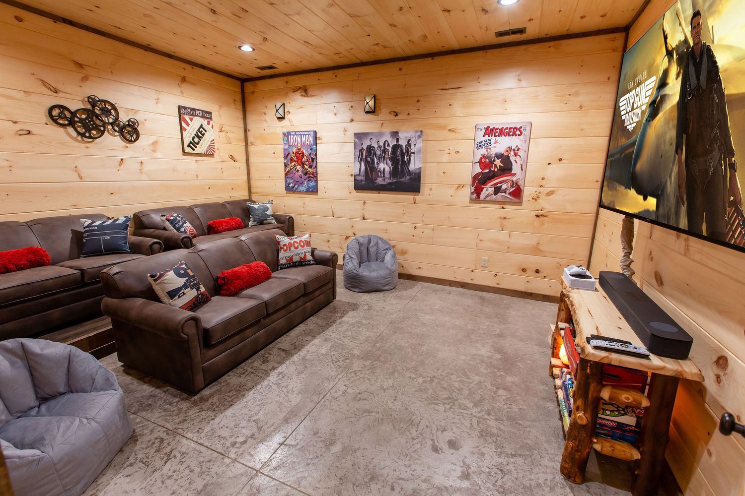 Panoramic view of a modern cabin game room with pool table, seating areas and wood-paneled walls.