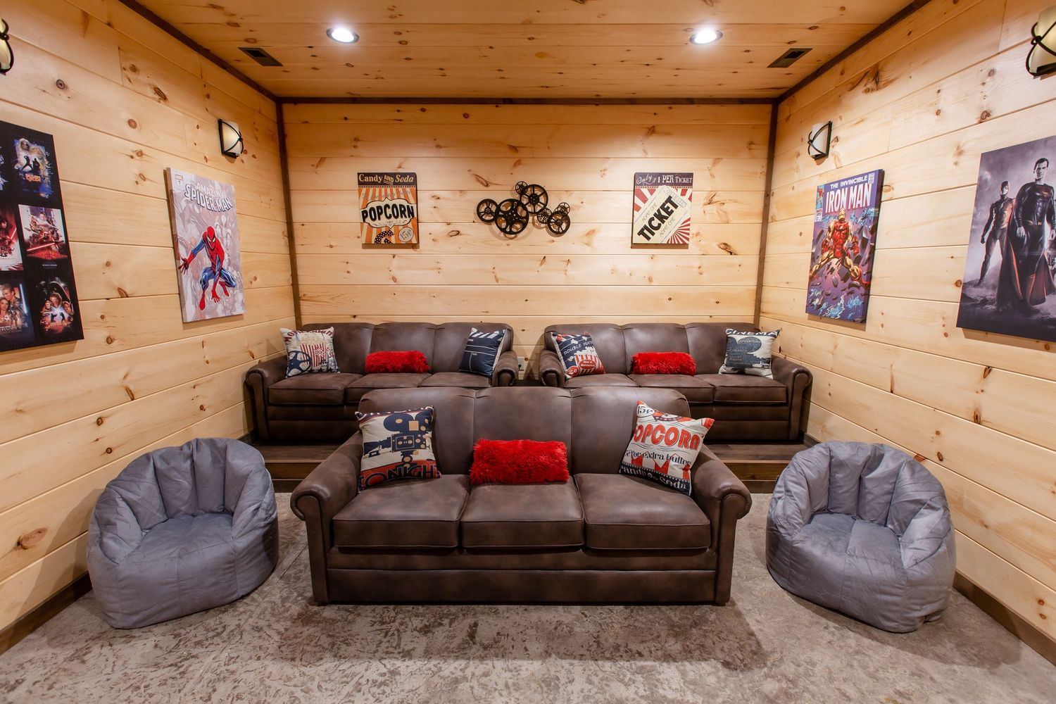 Cozy entertainment room with gray and brown couches, wood-paneled walls, and decorative wall art.
