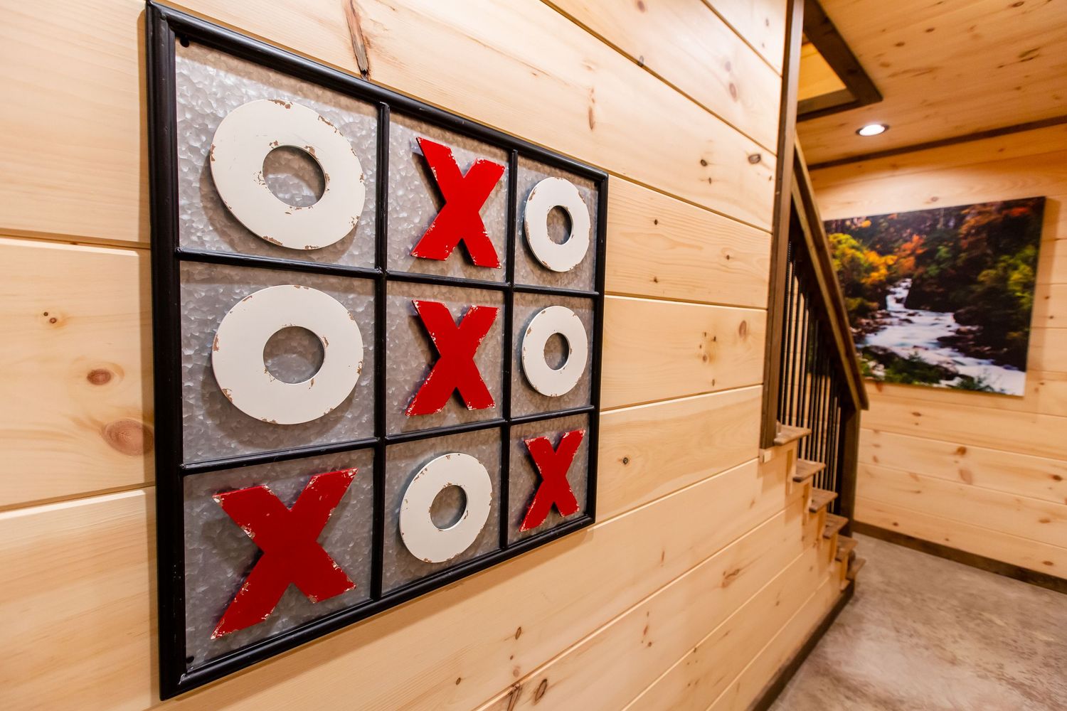 A modern tic-tac-toe themed wall art installation with red X's and white O's mounted on wooden paneled walls.