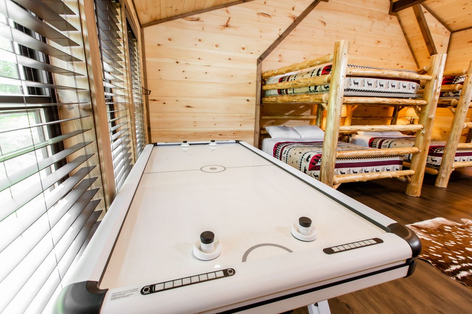 Sleek white countertop workspace with windows and built-in storage in a wooden-paneled room.