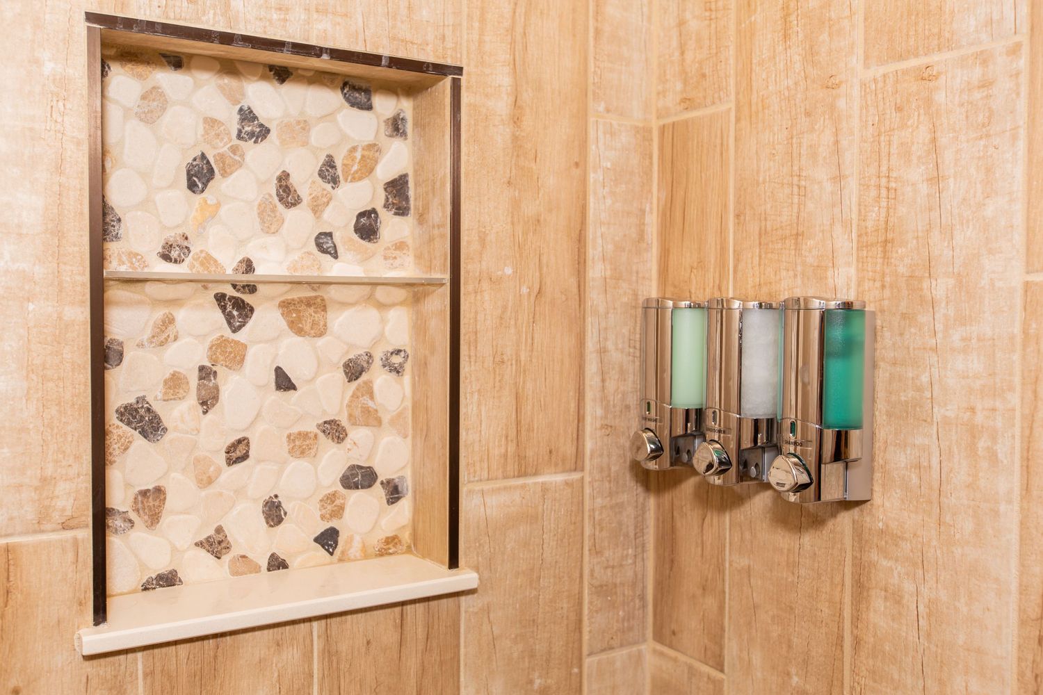 A modern bathroom interior with beige tiles, butterfly print curtains, and turquoise accents on the wall.