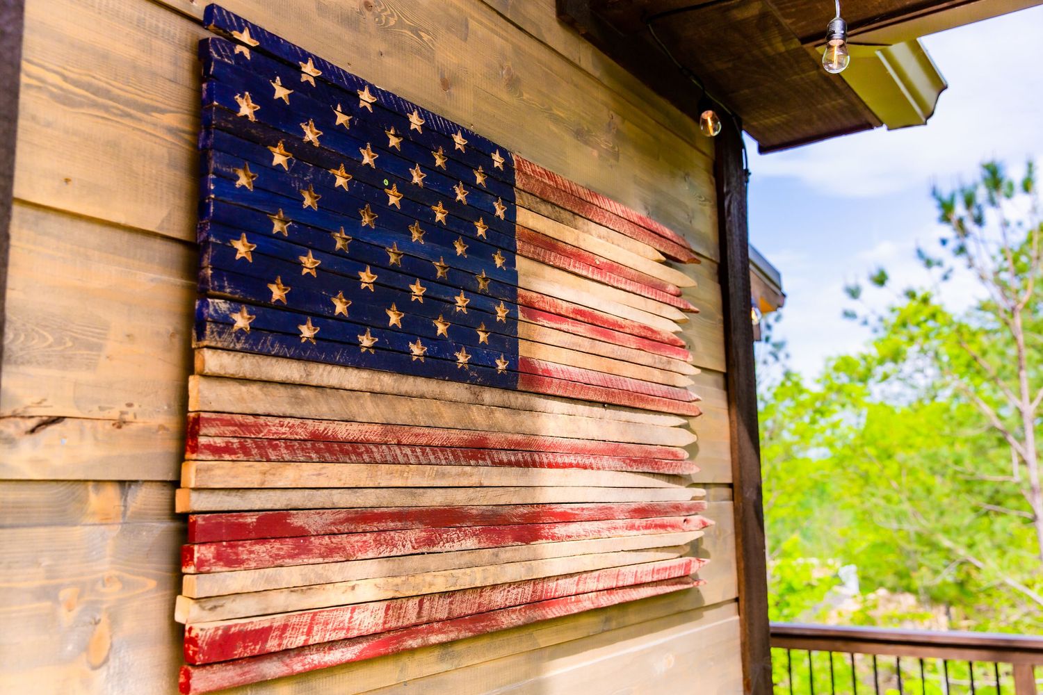 Rustic wooden porch decorated with painted American flag artwork.